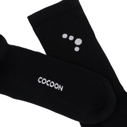 Black socks with 'Cocoon' branding on a white background