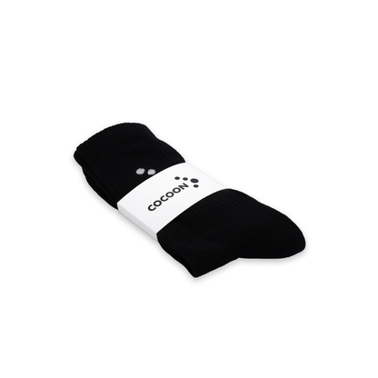 Black socks with a white band featuring 'Cocoon' branding on a white background