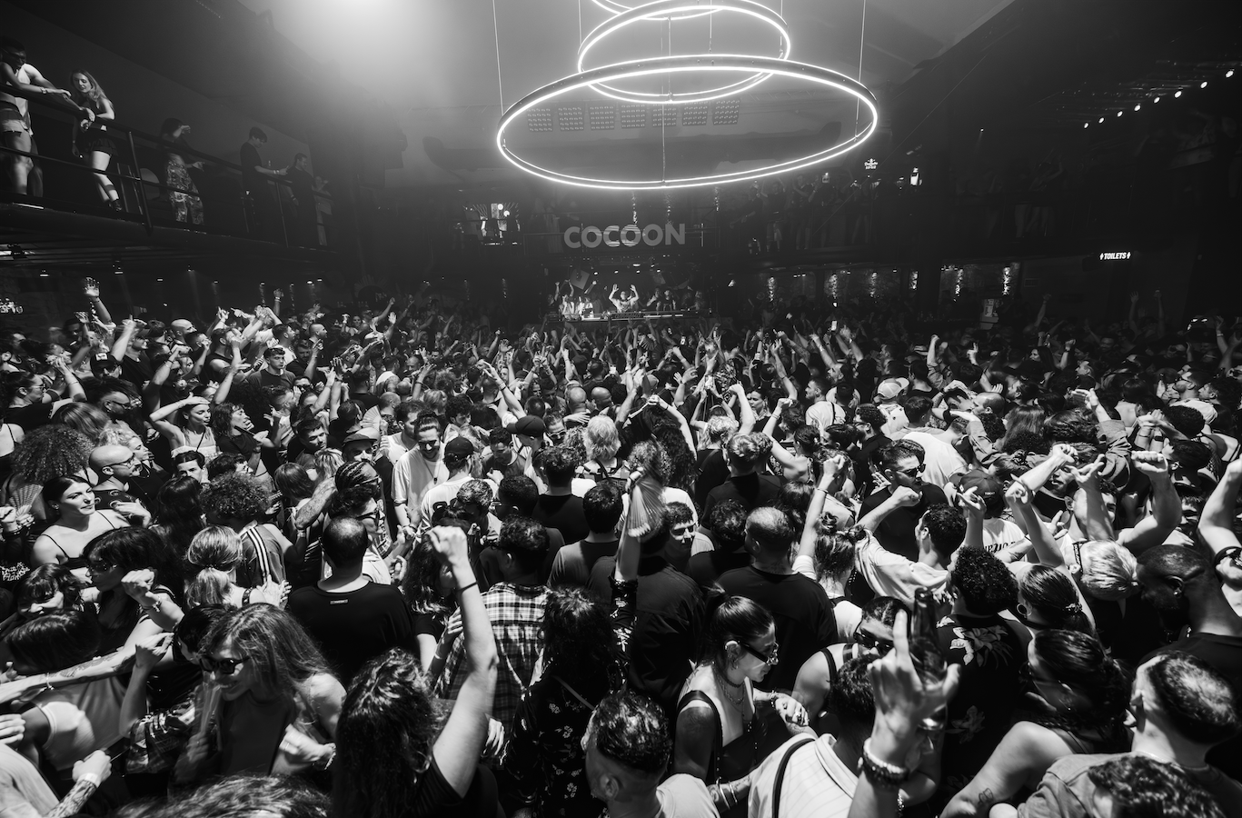 Large crowd at a Cocoon Amnesia Ibiza Event with 'Cocoon' branding in the background